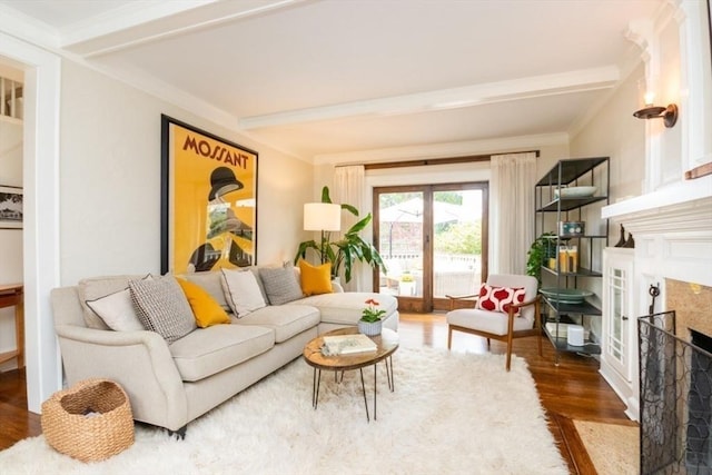 living area featuring a premium fireplace, beam ceiling, ornamental molding, and wood finished floors