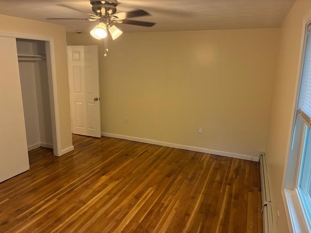 101 E Hadley Rd, Amherst, MA 01002 - unfurnished bedroom featuring baseboard heating, dark wood finished floors, ceiling fan, and a closet
