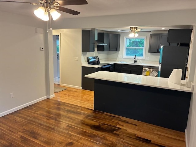 101 E Hadley Rd, Amherst, MA 01002 - kitchen with appliances with stainless steel finishes, a ceiling fan, a peninsula, hardwood / wood-style floors, and wall chimney exhaust hood