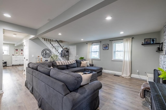 living area with baseboards, recessed lighting, wood finished floors, and stairway