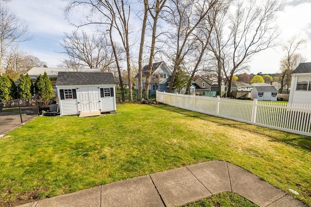view of yard with a fenced backyard, a shed, and a residential view