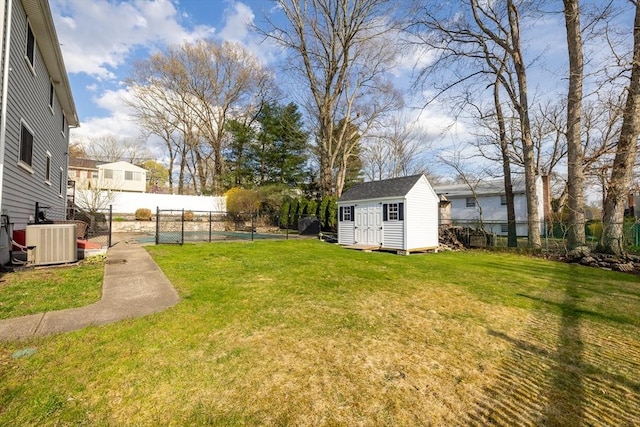 view of yard with central AC, an outdoor structure, a fenced backyard, and a storage unit