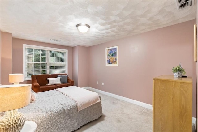bedroom featuring baseboards, light carpet, and a textured ceiling