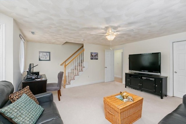 living room featuring stairway, light carpet, ceiling fan, and baseboards