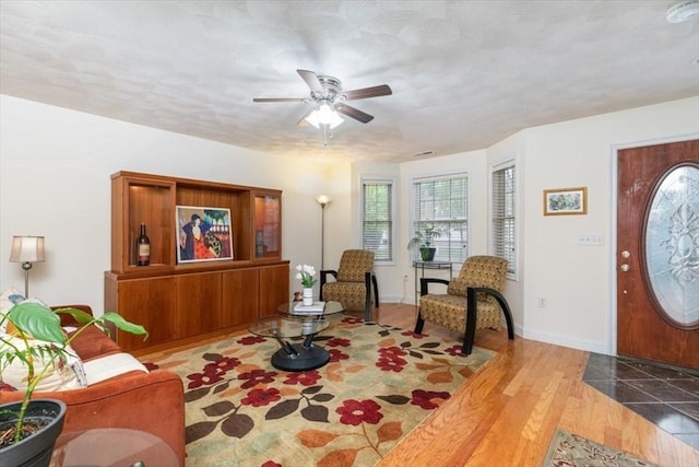entrance foyer with healthy amount of natural light, ceiling fan, baseboards, and wood finished floors
