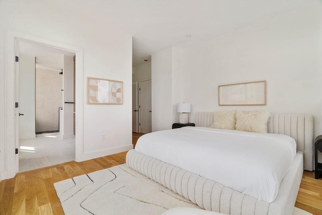 58 Kent St Unit 404, Brookline, MA 02445 - bedroom with wood finished floors, radiator, and baseboards