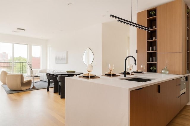 58 Kent St Unit 404, Brookline, MA 02445 - kitchen featuring a sink, modern cabinets, open shelves, light wood-style flooring, and light countertops