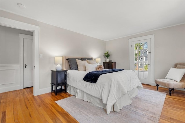 bedroom featuring light wood-style flooring, crown molding, and baseboards