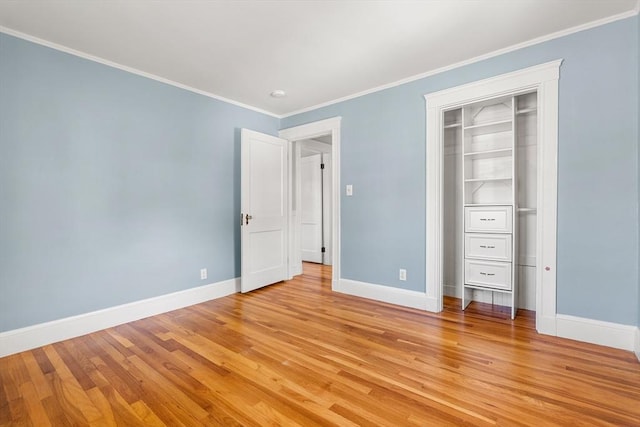 unfurnished bedroom featuring baseboards, light wood-style flooring, ornamental molding, and a closet
