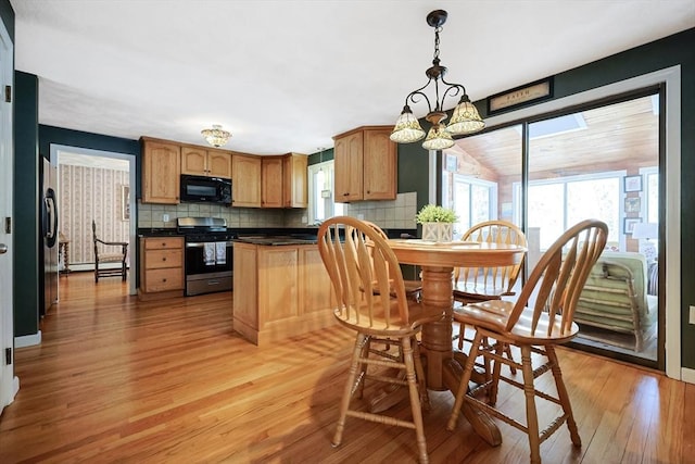 kitchen with tasteful backsplash, stainless steel range, dark countertops, decorative light fixtures, and black microwave