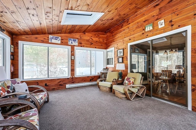 sunroom / solarium with a baseboard heating unit, lofted ceiling with skylight, wood ceiling, and a healthy amount of sunlight