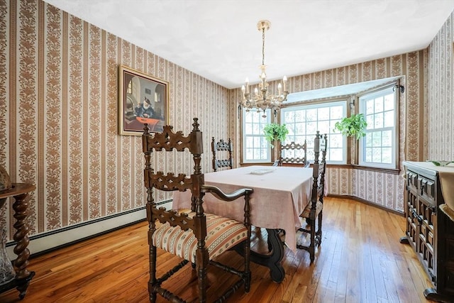 dining room featuring a chandelier, baseboards, baseboard heating, light wood-type flooring, and wallpapered walls