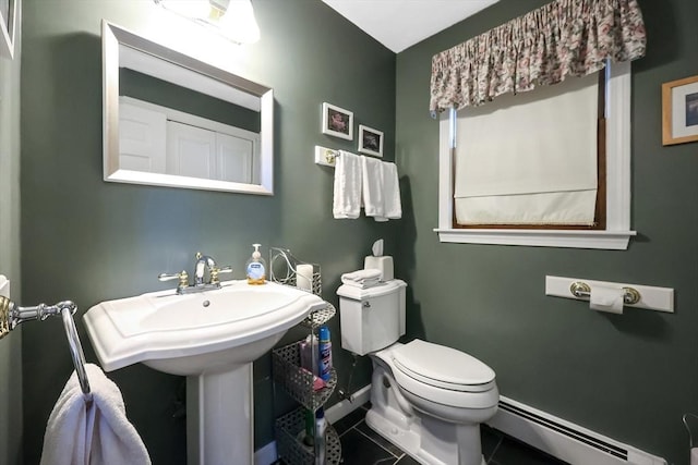 bathroom featuring baseboards, toilet, tile patterned flooring, baseboard heating, and a sink