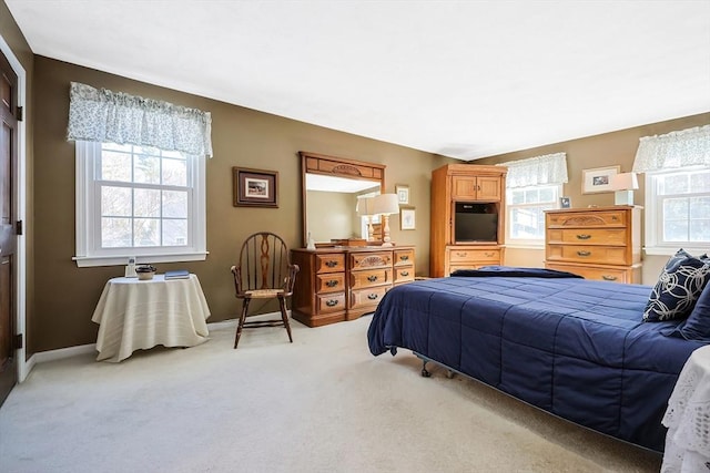 carpeted bedroom with multiple windows and baseboards