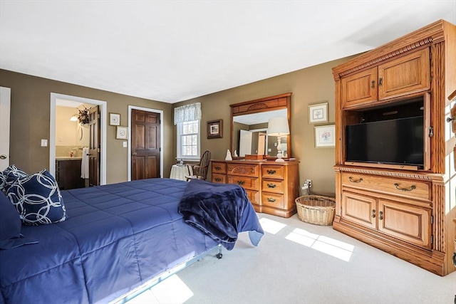 bedroom with light colored carpet and ensuite bath