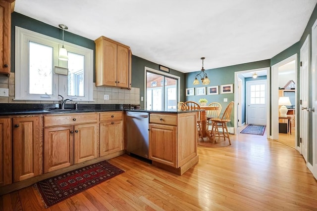 kitchen featuring dishwasher, a peninsula, light wood-type flooring, and pendant lighting