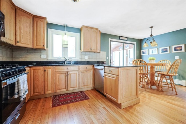 kitchen featuring stainless steel appliances, pendant lighting, a sink, and a peninsula