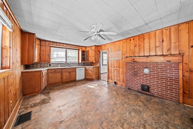 62 County St, Taunton, MA 02780 - kitchen with dishwasher, wood walls, brown cabinetry, ceiling fan, and light countertops