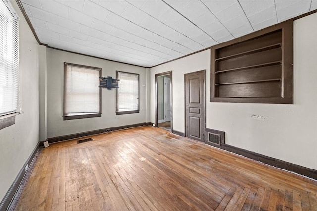 62 County St, Taunton, MA 02780 - empty room featuring built in shelves, crown molding, hardwood / wood-style floors, and baseboards