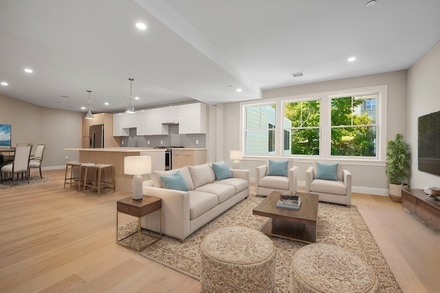 living room featuring sink and light hardwood / wood-style floors