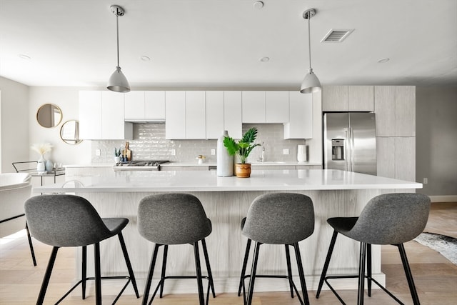 kitchen with appliances with stainless steel finishes, a kitchen island, and decorative light fixtures