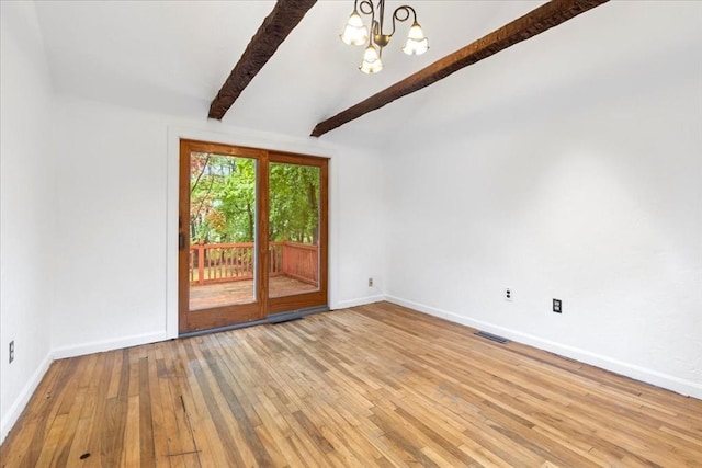 empty room with a chandelier, wood-type flooring, and baseboards