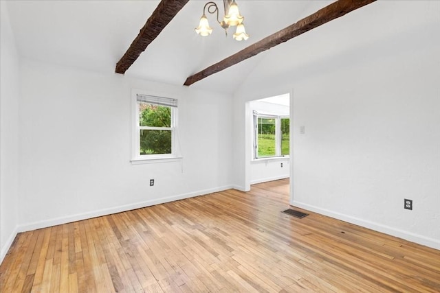 empty room featuring a chandelier, light wood-type flooring, and baseboards