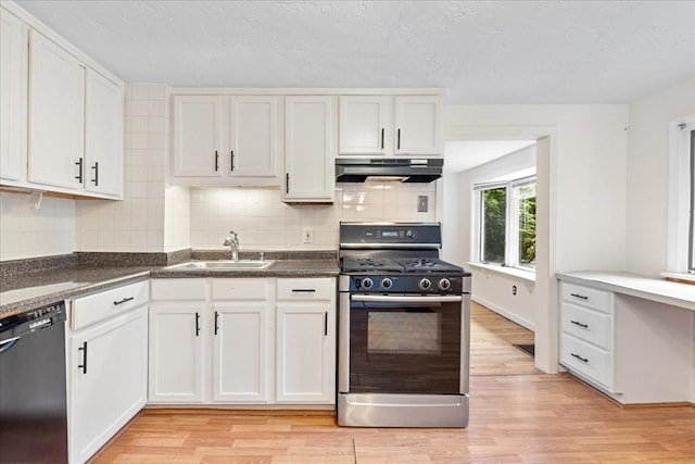 kitchen featuring range with gas stovetop, under cabinet range hood, dishwasher, a sink, and light wood-style flooring
