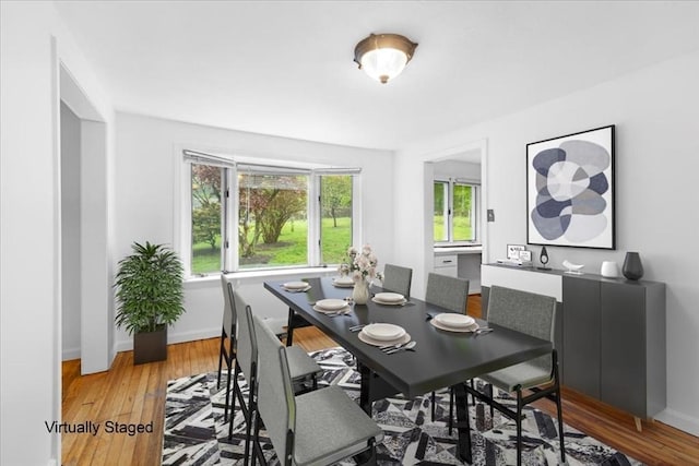 dining area featuring light wood finished floors and baseboards