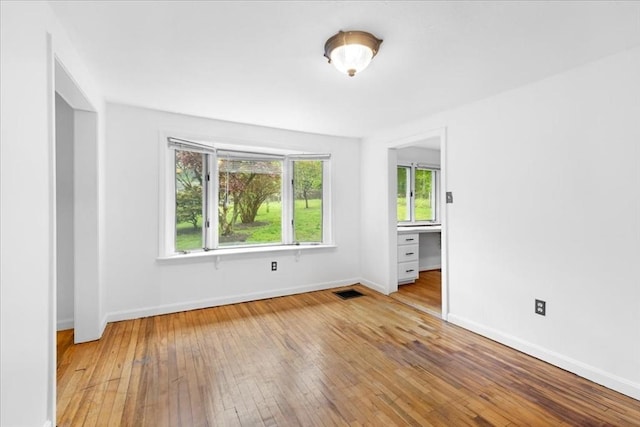 unfurnished room featuring hardwood / wood-style flooring and baseboards