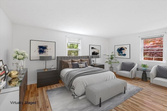 bedroom with light wood finished floors and baseboards