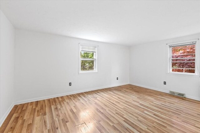 spare room with light wood finished floors and baseboards