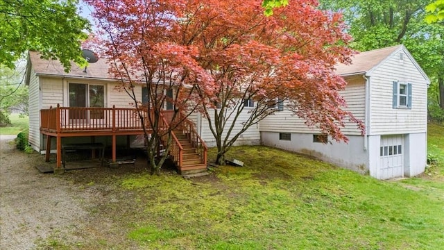 back of house with a wooden deck, a lawn, stairs, and a garage