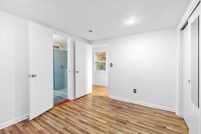 unfurnished bedroom with light wood-style flooring, baseboards, and a closet