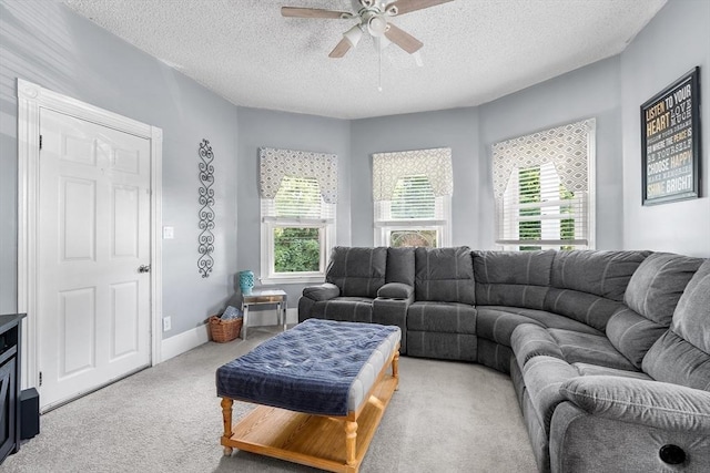 living area with a textured ceiling, plenty of natural light, baseboards, and light colored carpet