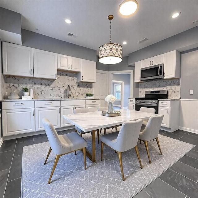 kitchen with white cabinetry, visible vents, appliances with stainless steel finishes, and a sink