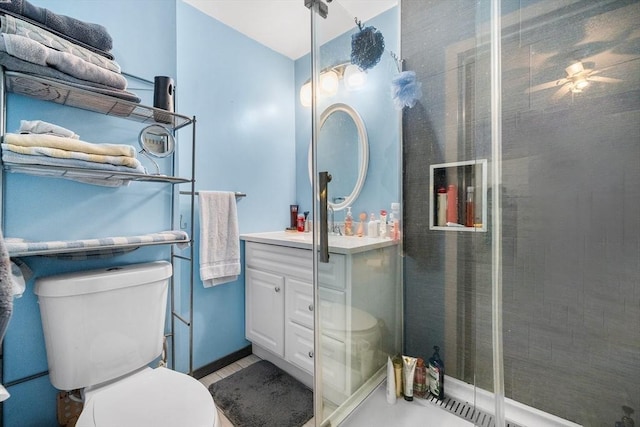 bathroom featuring toilet, a stall shower, and vanity