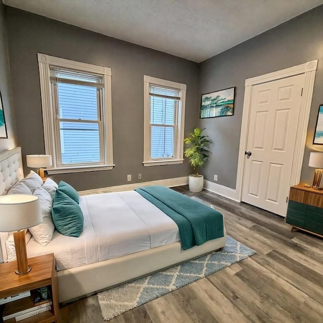 bedroom with baseboards and wood finished floors