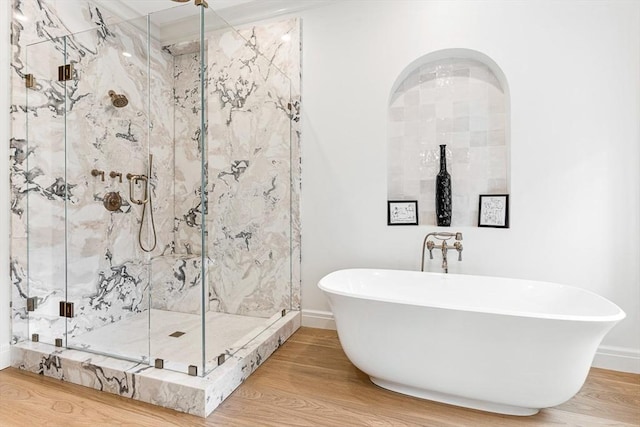 bathroom with a freestanding tub, wood finished floors, and a marble finish shower