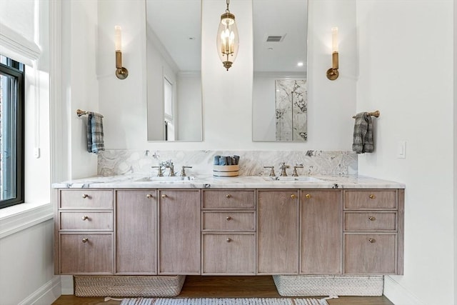 full bathroom featuring double vanity, baseboards, visible vents, and a sink