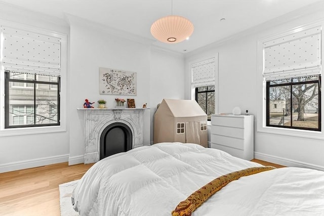 bedroom featuring multiple windows, baseboards, and wood finished floors