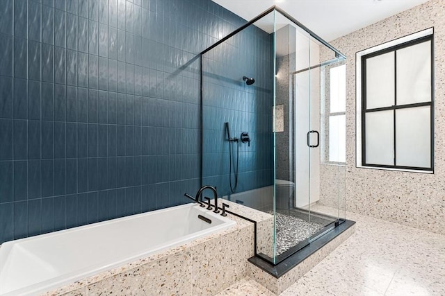 bathroom featuring a stall shower and a bath