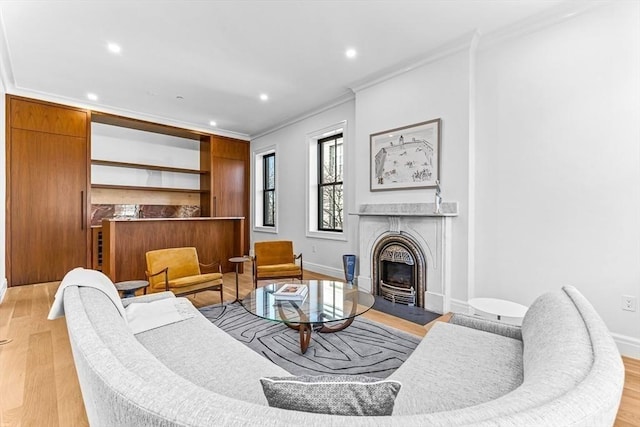 living area featuring recessed lighting, light wood-style floors, baseboards, and ornamental molding