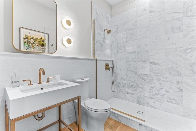 bathroom with toilet, tile walls, walk in shower, and wood finished floors