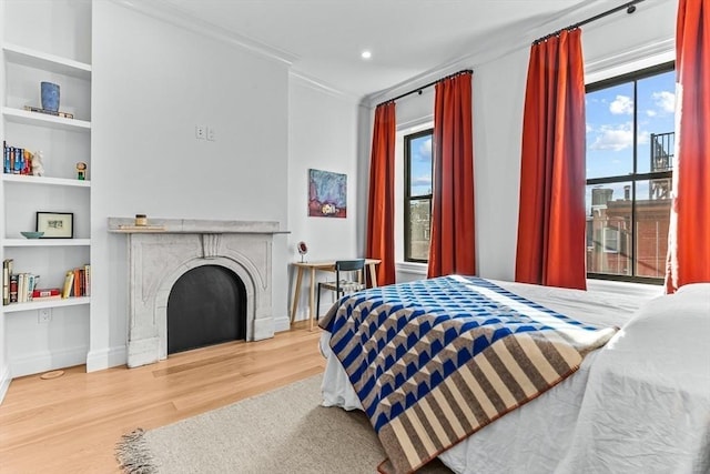 bedroom with recessed lighting, a fireplace, baseboards, and wood finished floors