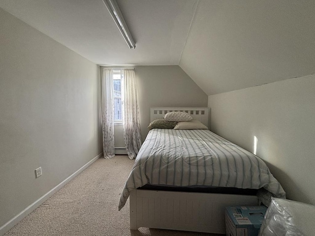 carpeted bedroom with baseboard heating and vaulted ceiling