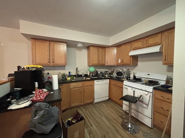 kitchen featuring sink, dark wood-type flooring, and white appliances