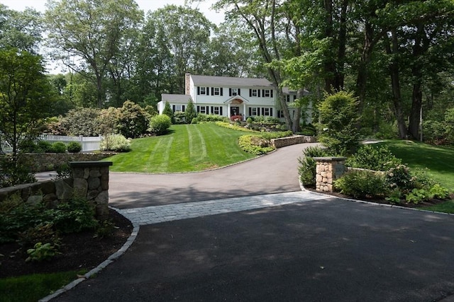 130 Hickory Rd, Weston, MA 02493 - view of front of home with asphalt driveway, a front yard, and a chimney
