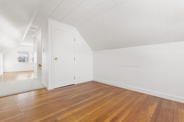 additional living space with hardwood / wood-style flooring and lofted ceiling