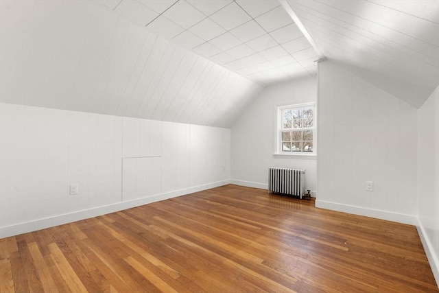 bonus room featuring hardwood / wood-style floors, radiator heating unit, and vaulted ceiling